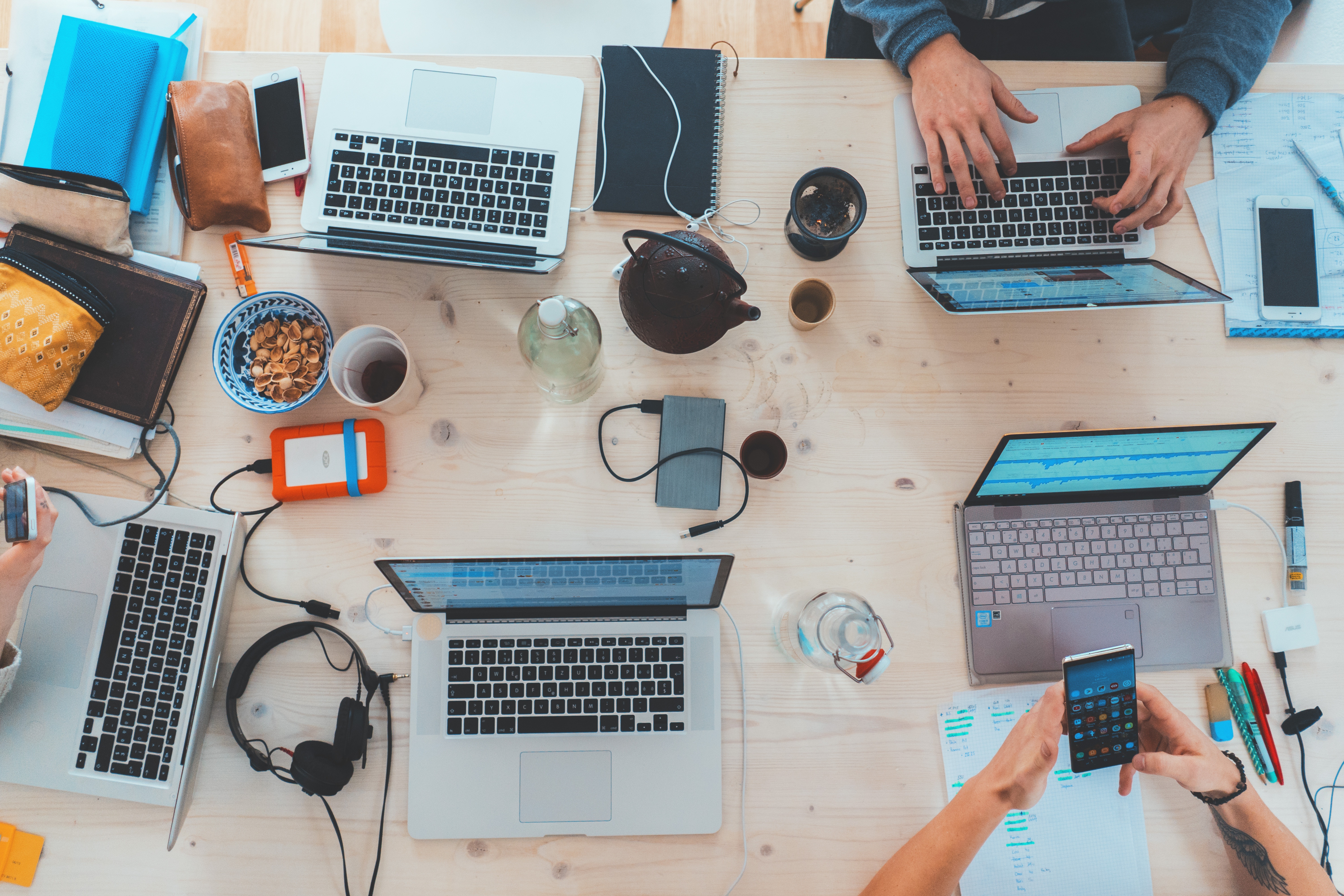 A table full of laptops, snacks, and drinks